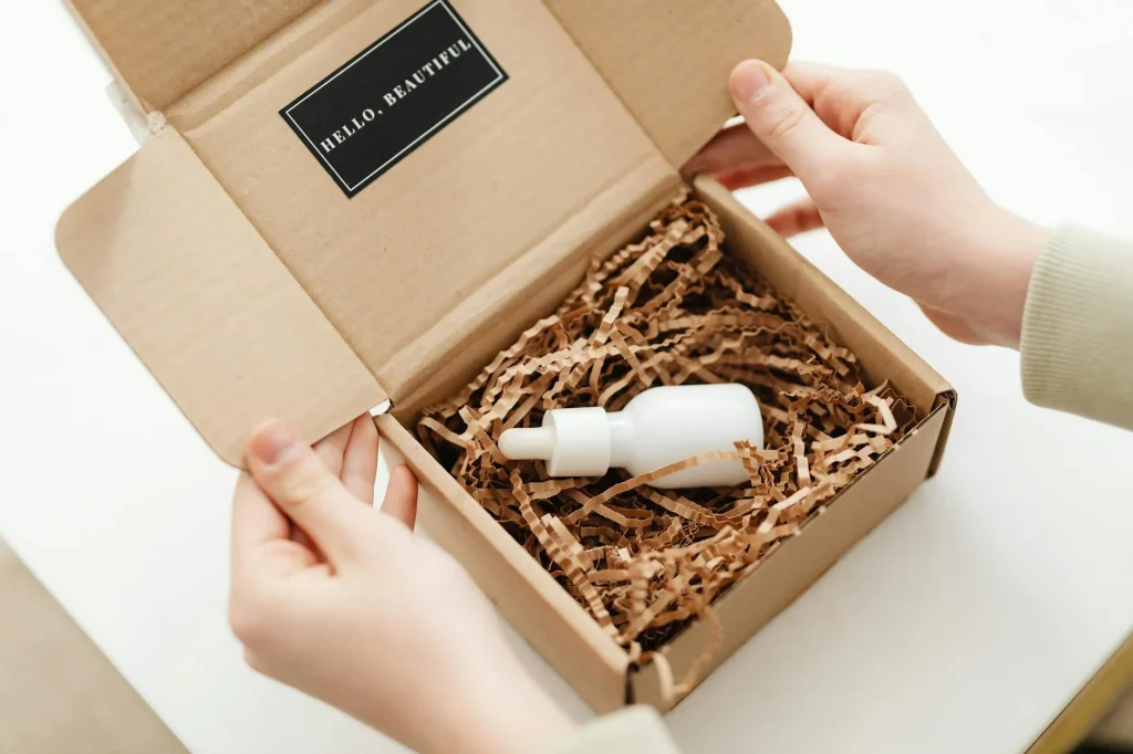 Slimmit酵素膠原凍開箱:產品實拍、口感評測、30天使用紀錄 1 Hands opening a package with a skincare dropper bottle in protective packaging.