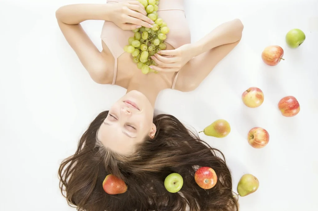 Slimmit食事對抗酵素膠原凍與健康生活 5 Woman lying down with fresh fruits symbolizes beauty and wellness.